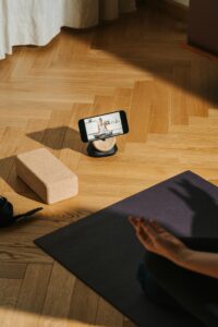 A serene home yoga setup with phone streaming class and mat for well-being.